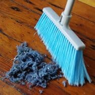 A blue broom sweeping up blue dust.