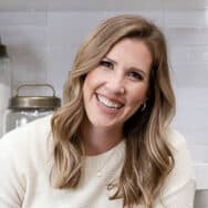 Lauren Allen sitting on a kitchen countertop, looking at the camera and smiling