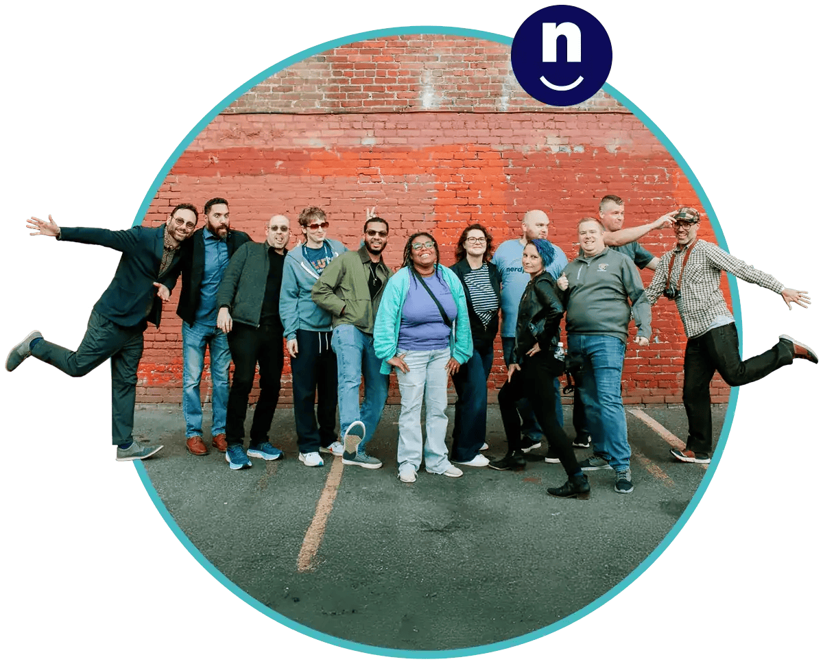 a group of people standing in front of a brick wall. they are making funny faces at one another and seem to be happy and having fun.