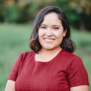 Crystal in a burgundy shirt, smiling at the camera.
